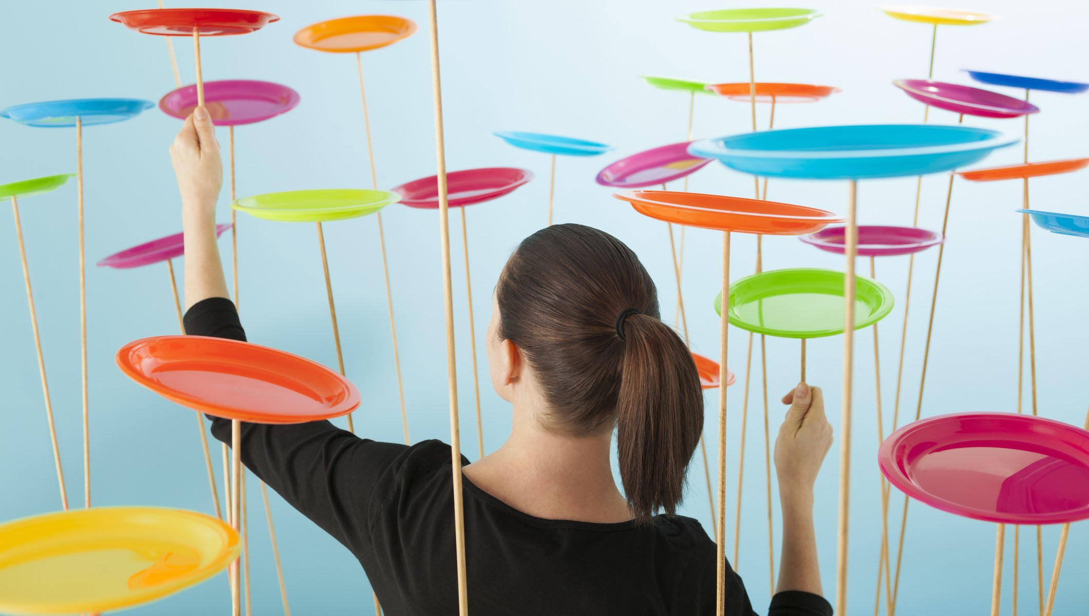 Woman spinning colorful plates represents trying to manage documents without document control