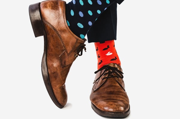 Close up photo of stylish shoes brown shoes  and multicolored socks on a white background