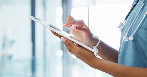 Medical assistant recording a patient's record on a tablet | Healthcare document management