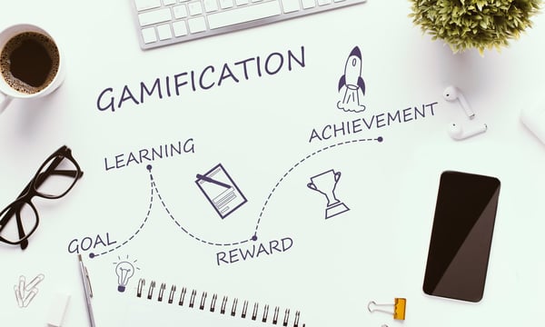 Gamification increase employee productivity with these steps: Goal, Paper on a desk with the word gamification on it represents the potential for learning, rewards and achievement through gamification